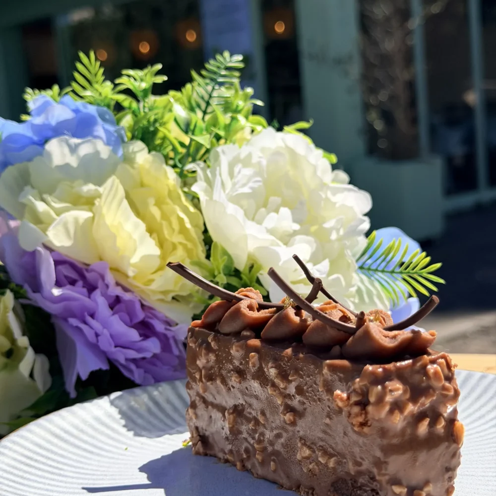 Part de pâtisserie Écureuil chocolat noisette caramel, création artisanale halal servie en terrasse à La manufacture du goût, boulangerie-pâtisserie à Champigny-sur-Marne (94)